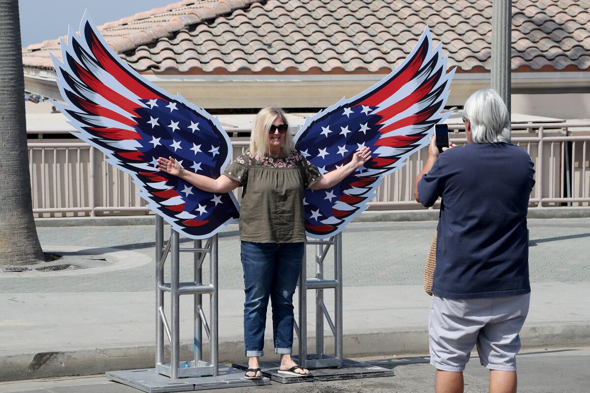 A woman has her picture taken at the Pier Plaza Fourth of July Festival in Huntington Beach on Friday.