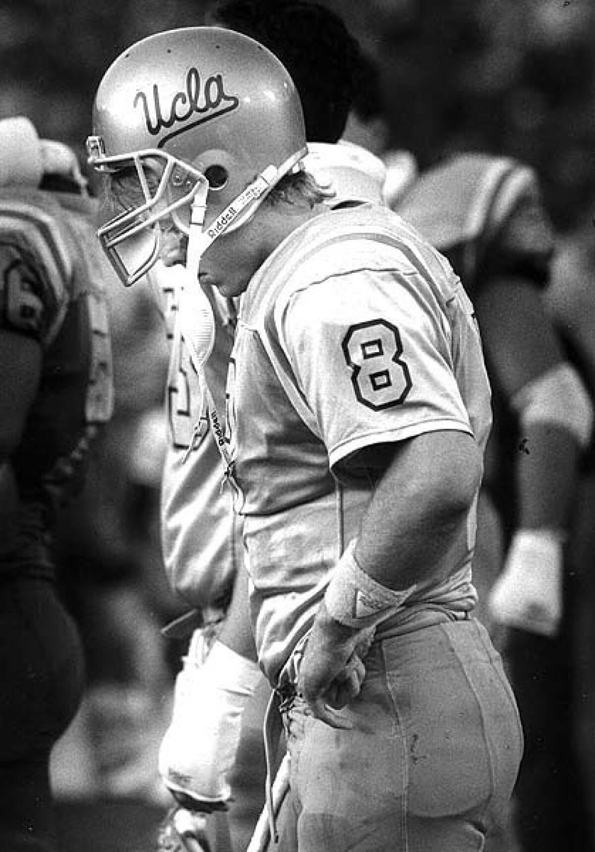 UCLA quarterback Troy Aikman walks off the field after the 31-22 loss to USC.