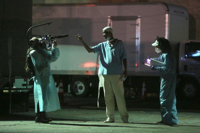 LOS ANGELES, CA - OCTOBER 01: Basim Abdel-Aziz, center, rehearses with colleagues for 5711 Avalon, a Slauson Rec. Theater Company play that explores a drive through COVID-19 testing site in South Los Angeles on Thursday, Oct. 1, 2020 in Los Angeles, CA. (Dania Maxwell / Los Angeles Times)