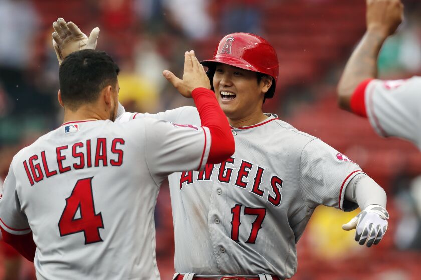 Los Angeles Angels' Shohei Ohtani (17) celebrates his two-run home run with teammate Jose Iglesias.