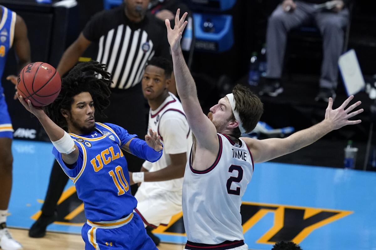UCLA guard Tyger Campbell passes around Gonzaga forward Drew Timme during the 2021 Final Four.