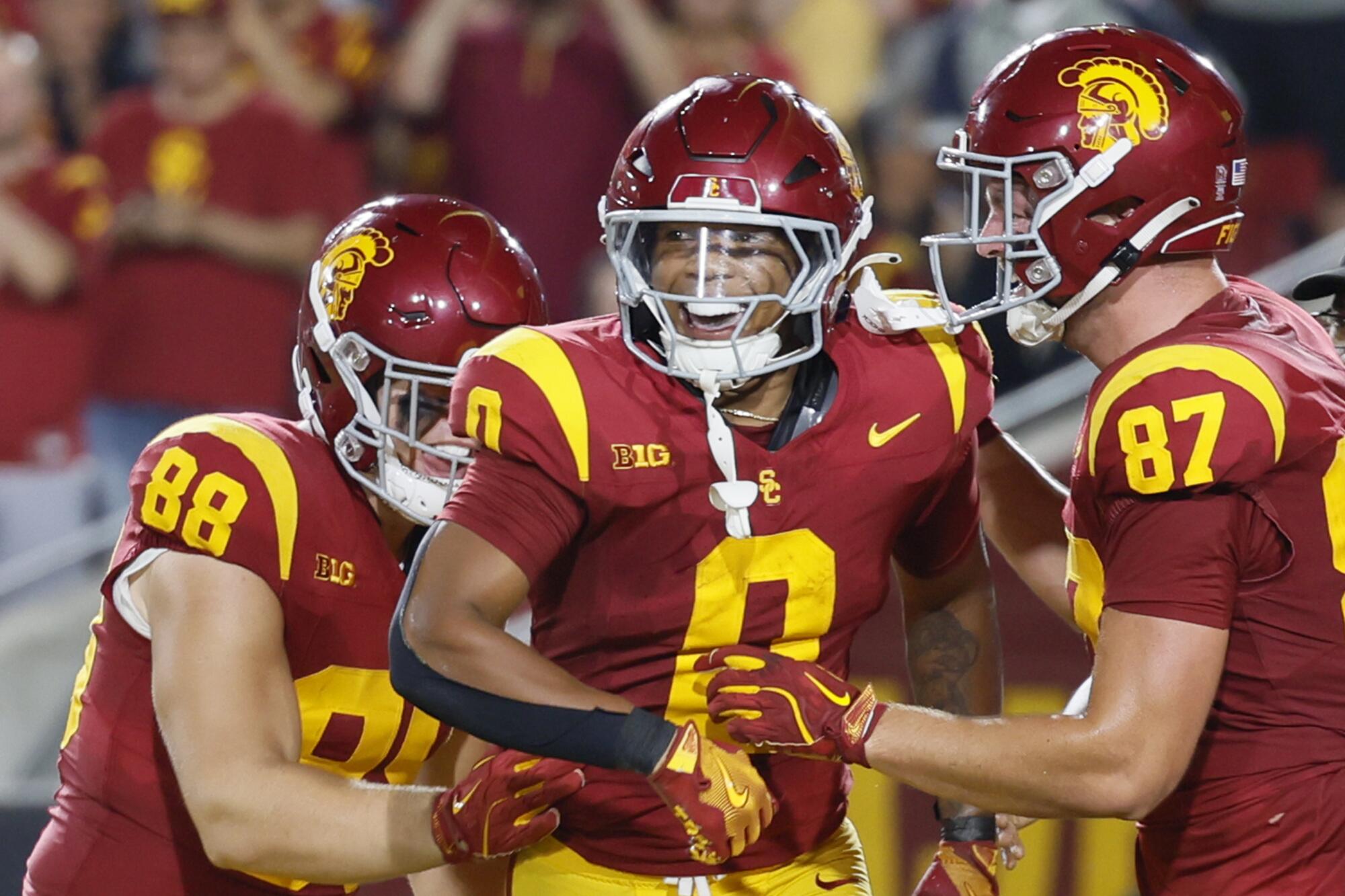 USC running back Quinten Joyner celebrates with teammates after scoring a touchdown against Utah State at the Coliseum.