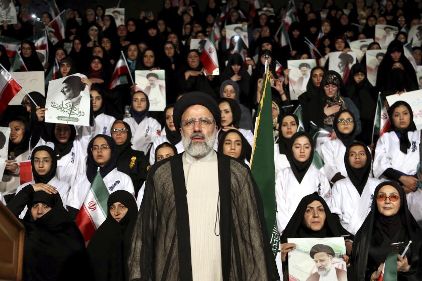 FILE - In this April 29, 2017, file photo, Iranian cleric and presidential candidate Ebrahim Raisi, center, stands among his supporters, during a campaign rally in Tehran, Iran. Raisi, a prominent hard-line cleric who now serves as Iran's judiciary chief, registered Saturday, May 15, 2021, to run in Iran's upcoming presidential election. (AP Photo/Ebrahim Noroozi, File)