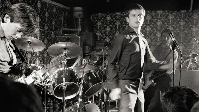 Bernard Sumner, left, Ian Curtis and Peter Hook of Joy Division perform at the Bowdon Vale Youth Club in Britain, circa 1979.