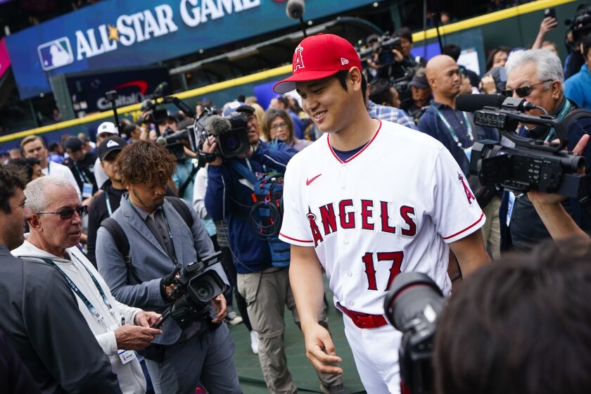Shohei Ohtani jugador de Los Angelinos de Los Ángeles de la Liga Americana sonríe mientras camina hacia los jardines luego de atender a los medios en Seattle. Lunes 10 de julio de 2023. (AP Foto/Lindsey Wasson)