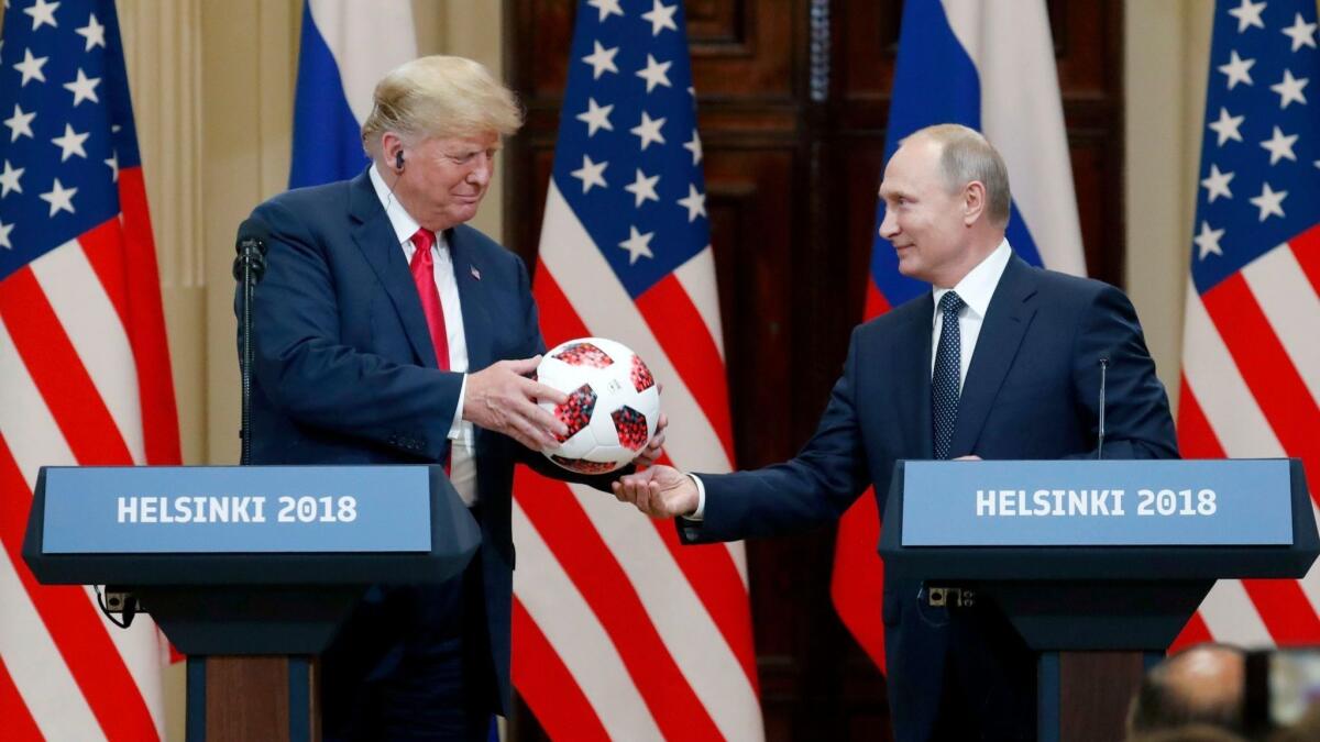 President Trump accepts a soccer ball as a gift from Russian leader Vladimir Putin during a news conference in Helsinki, Finland, on July 16.