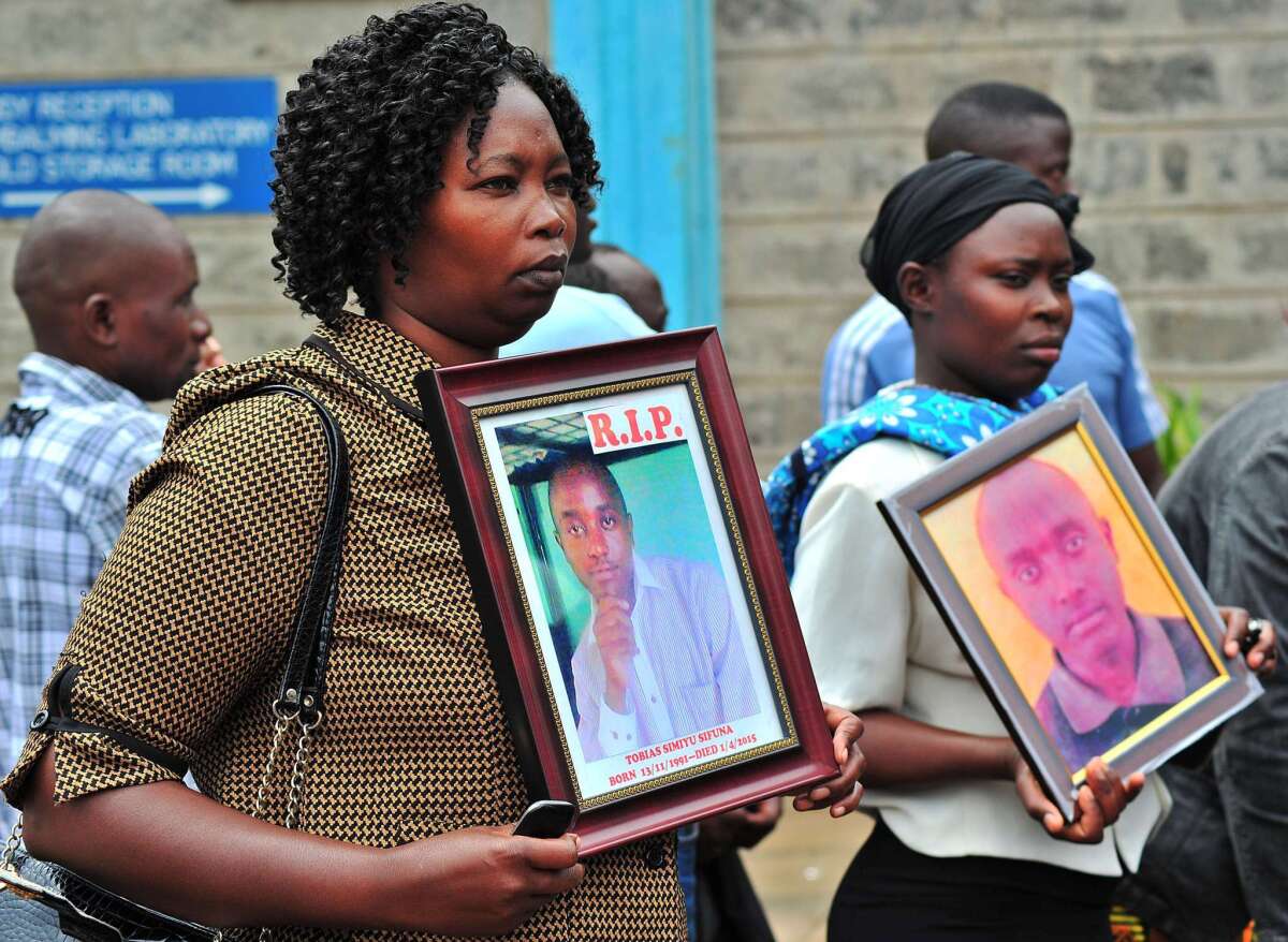 Relatives of those killed in the terror attack at Kenya's Garissa University College hold portraits of their kin on April 9 as they wait to retrieve victims' bodies from a morgue in Nairobi.
