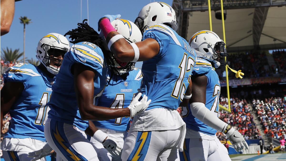 Chargers wide receiver Travis Benjamin, middle, is congratulated by teammate Keenan Allen (13) after scoring on a 65-yard return during the first half Sunday.