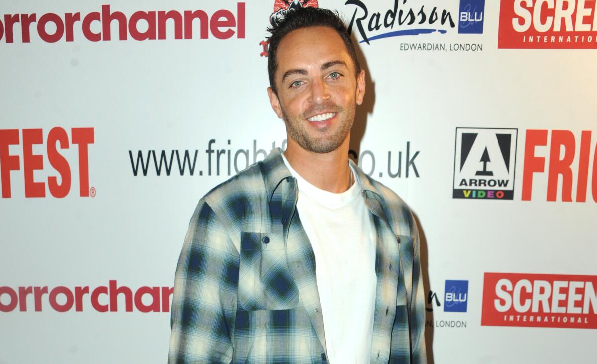 Zachary Horwitz stands in front of a backdrop with film festival logos on it at a screening