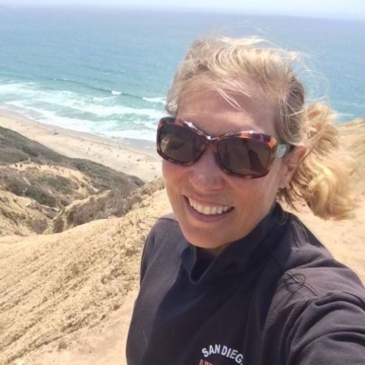 La Jollan Elizabeth "Liz" Palmer was the first female lifeguard to work at Black's Beach (pictured behind her).