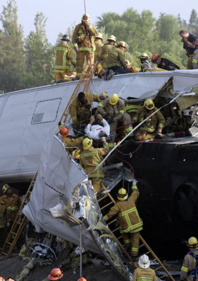 Emergency personnel rescue an injured passenger from a passenger car after the deadly collision between a Metrolink commuter train and a Union Pacific freight train in Chatsworth on Sept. 12, 2008.