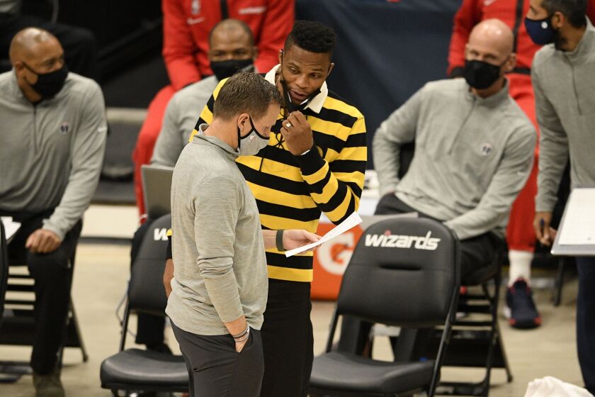 Washington Wizards guard Russell Westbrook, back, talks with head coach Scott Brooks, front, during the second half of a preseason NBA basketball game against the Detroit Pistons, Thursday, Dec. 17, 2020, in Washington. (AP Photo/Nick Wass)