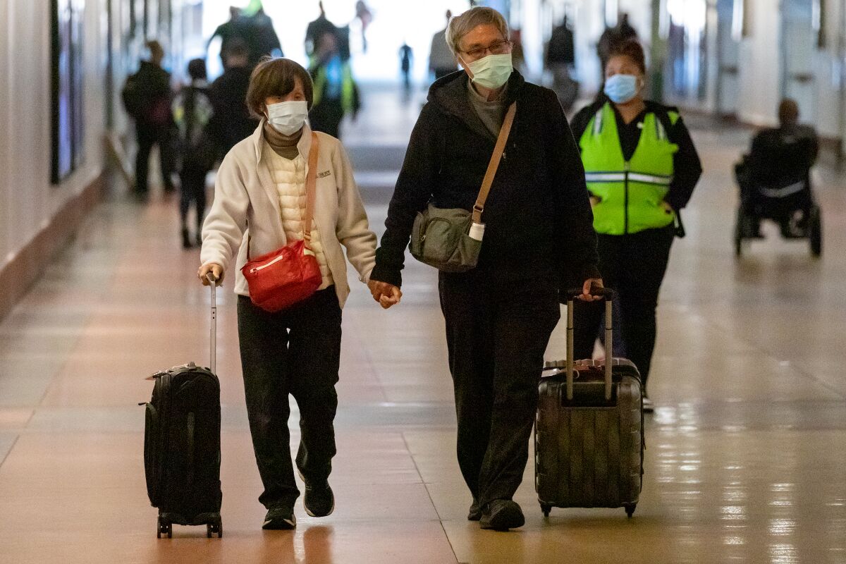 Commuters with and without face masks pass through Los Angeles Union Station on Dec. 6. 