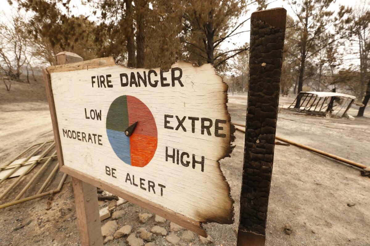 A burned sign warns of fire danger at The Outdoor School at Rancho Alegre Boy Scout camp along State Highway 154 in the Santa Ynez Valley.