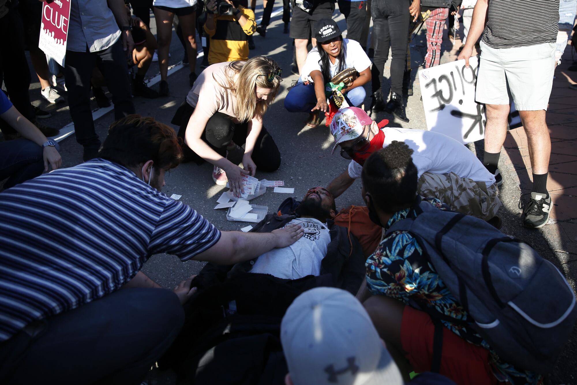 People tend to an injured protester on the 101 Freeway near downtown Los Angeles