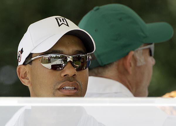 Tiger Woods rides in a golf cart with his caddie, Steve Williams, at the Augusta National Golf Club in Georgia, where the Masters tournament begins this week, marking the golfer's return to the tour.