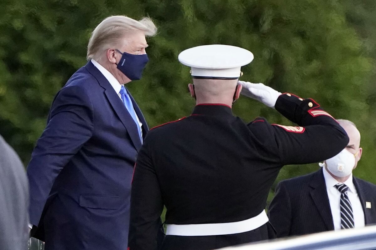 President Trump in a mask walks past a saluting Marine