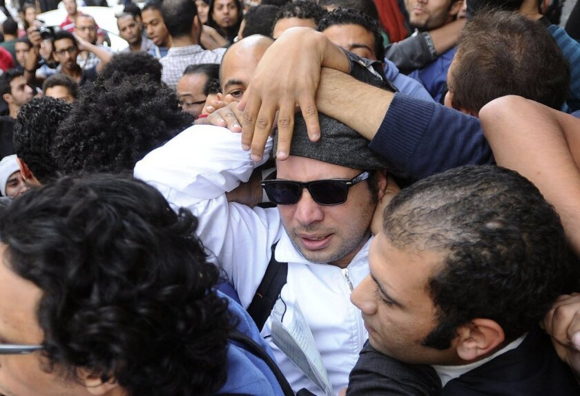Ahmed Maher, center, a leader of the April 6 Youth Movement in the 2011 uprising against Egyptian President Hosni Mubarak, tries to turn himself in to prosecutors in Cairo in November 2013 over an arrest warrant that charged him with inciting demonstrations against a new protest law.