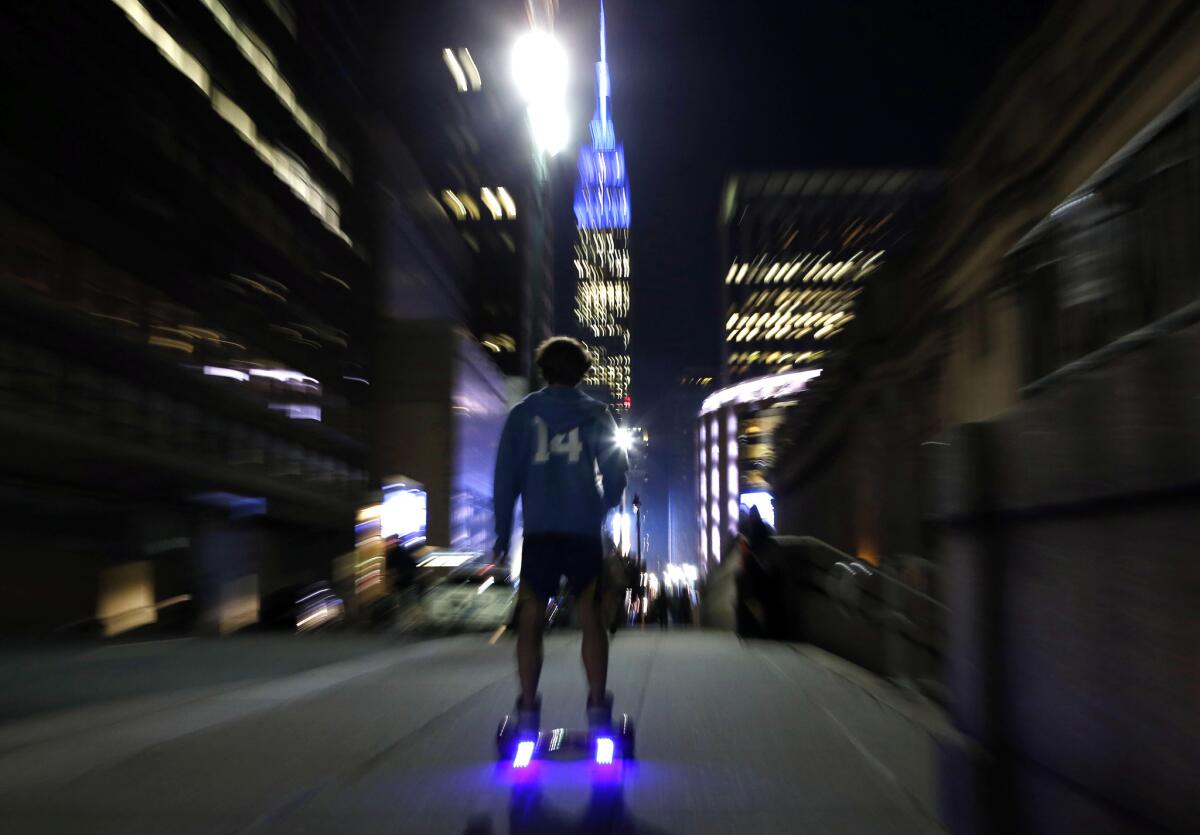 In this 2015 file photo, a young man rides a hoverboard along a Manhattan street.