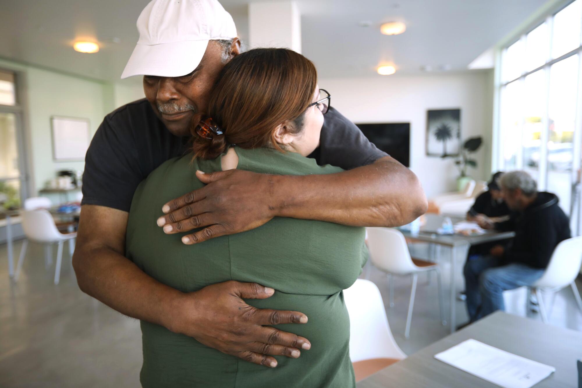 A man and a woman hug at an apartment complex