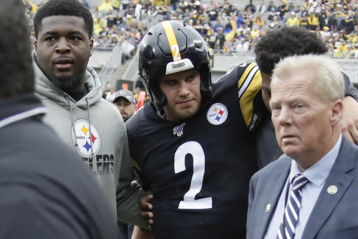 Mason Rudolph is helped from the field after he was knocked out.