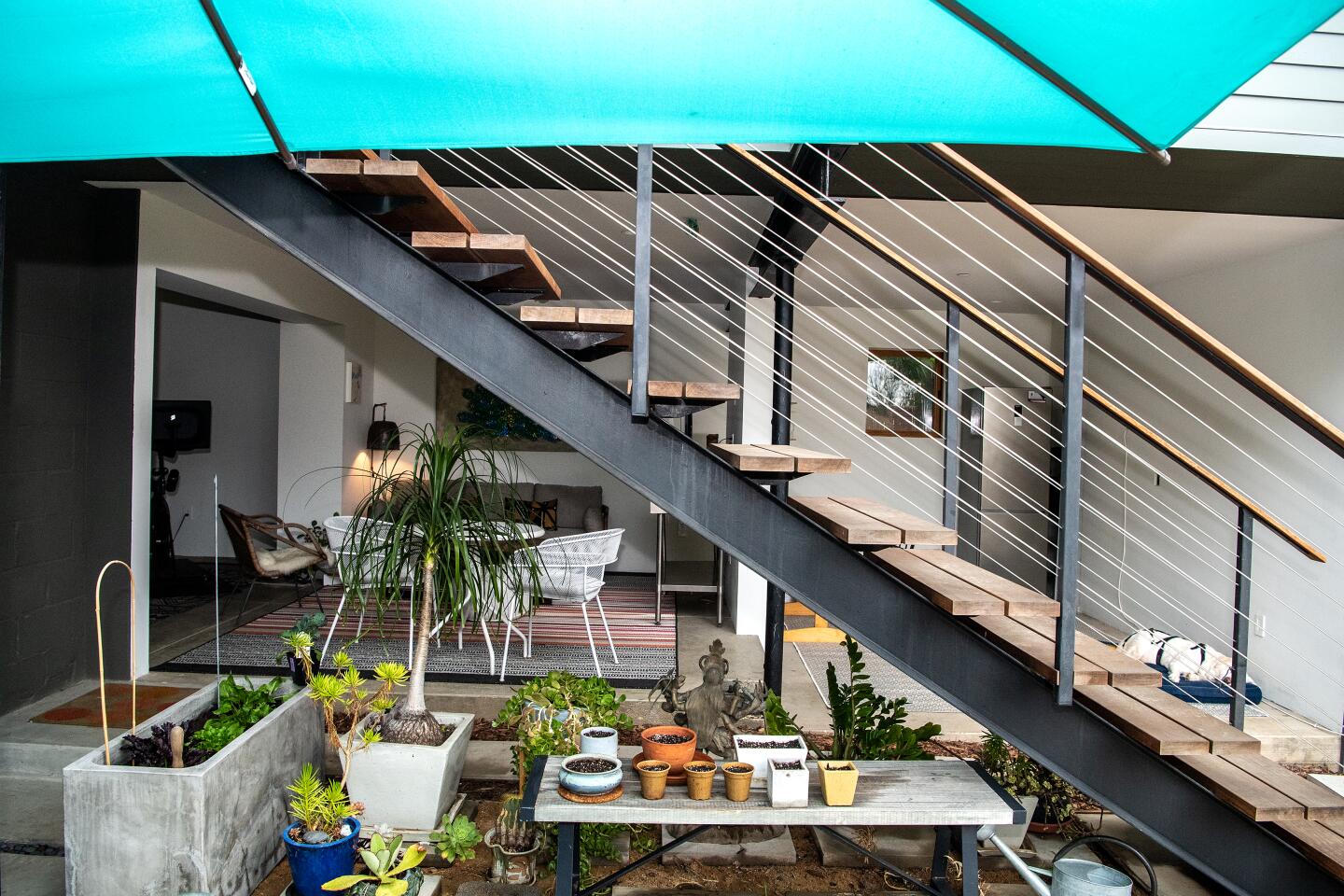 An outdoor living area is located beneath the ADU, which is accessed by stairs.