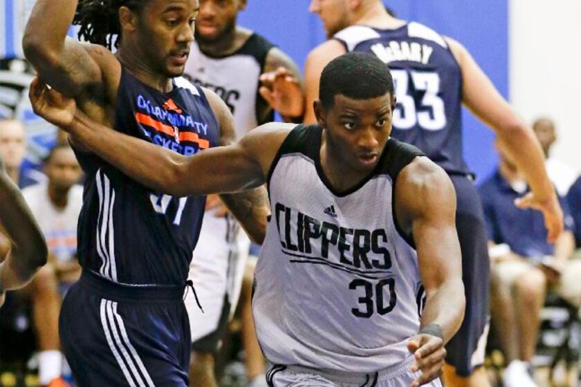 Clippers guard C.J. Wilcox works his way around Oklahoma City guard Levi Randolph, left, during the second half of an NBA summer league game Tuesday in Orlando.