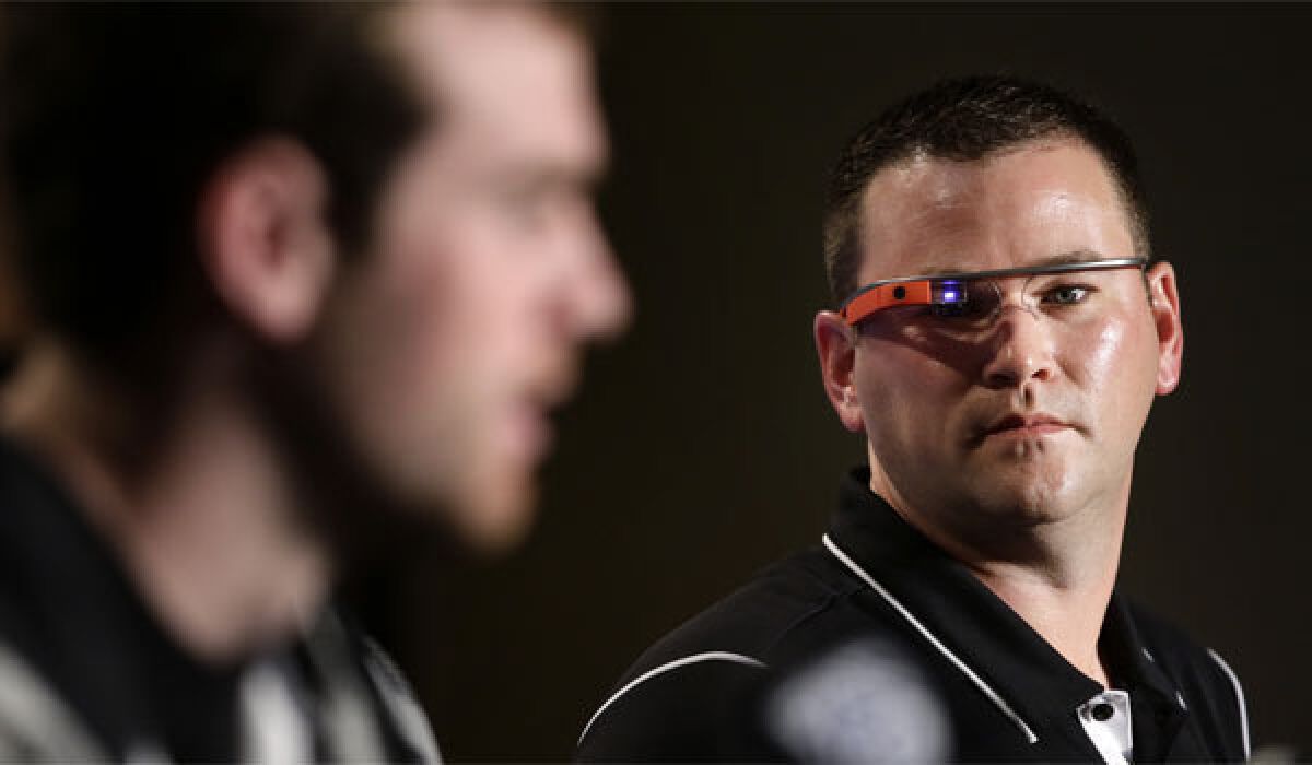 Stanford offensive coordinator Mike Bloomgren, right, wears Google Glass while listening to quarterback Kevin Hogan during a news conference on Friday.
