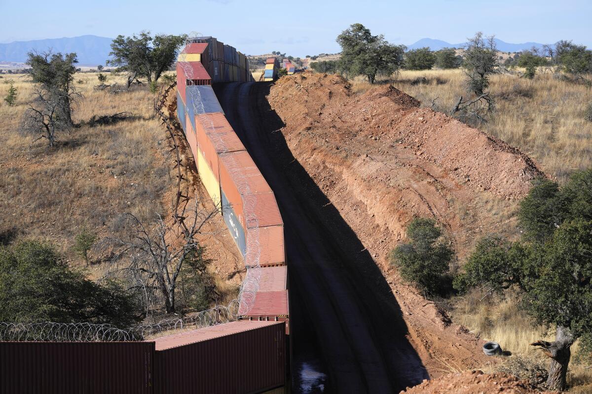 Una larga hilera de contenedores encimados proporciona un muro provisional en la frontera 