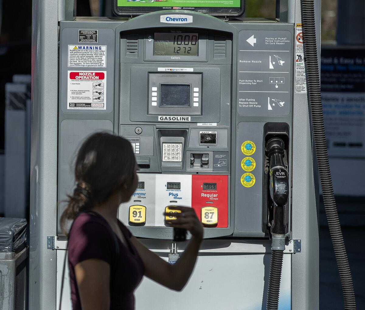 A woman at a gas pump.