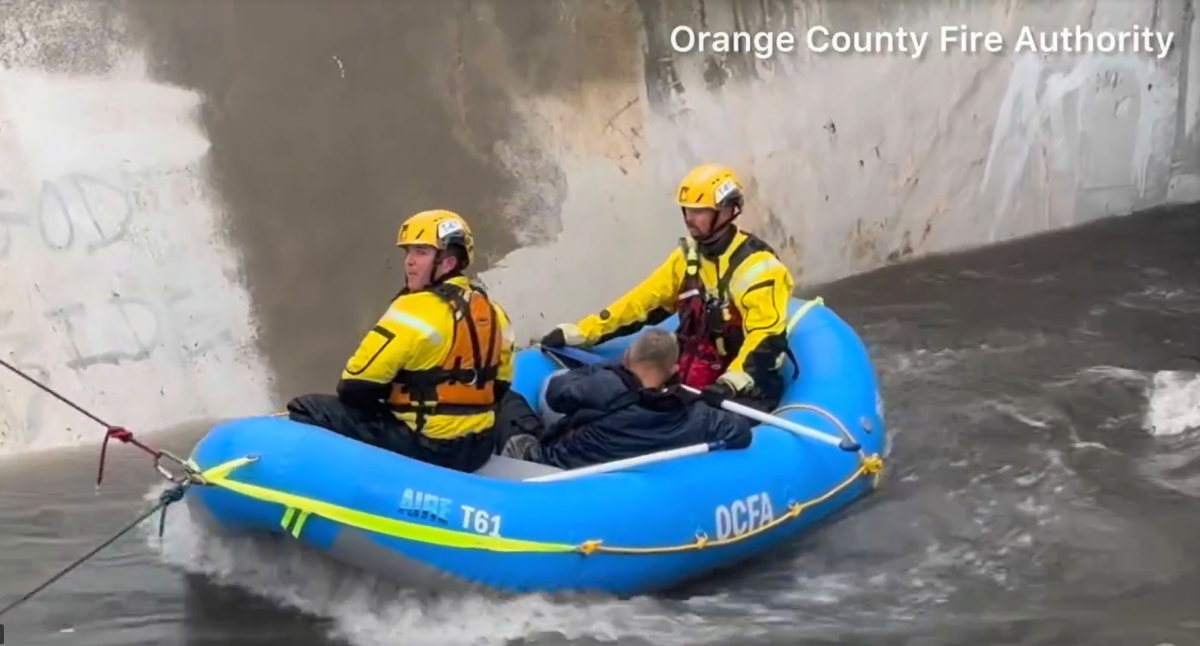 An unidentified adult male is pulled Thursday from a Costa Mesa flood control channel by an OCFA swift water rescue team.
