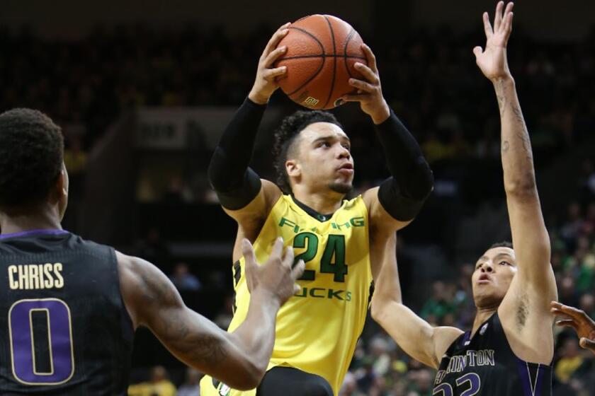 Oregon forward Dillon Brooks (24) drives to the basket between Washington's Marquese Chriss (0) and Dominic Green, right, during the first half.