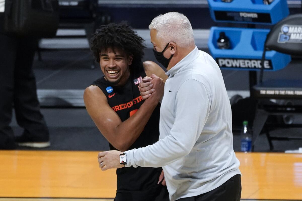 Oregon State guard Ethan Thompson and coach Wayne Tinkle celebrate.