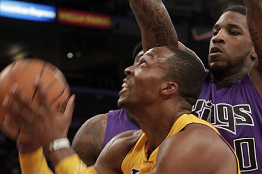 Lakers center Dwight Howard, left, is defended by forward Thomas Robinson, then with the Sacramento Kings, in October. Robinson, now with Houston, will be traded to the Portland Trail Blazers as the Rockets pursue Howard.