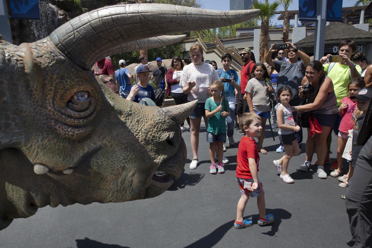 UNIVERSAL CITY, CALIF. - JULY 17, 2019: Spectators take photos of the trisaurus “Juliet” at Jurassic Park at Universal Studios Hollywood in Universal City, Calif. on Wednesday, July 17, 2019. (Liz Moughon / Los Angeles Times)