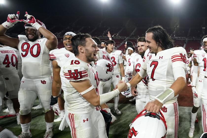 Utah quarterback Cameron Rising, right, and wide receiver Britain Covey (18) celebrate the team's win over USC on Oct. 9
