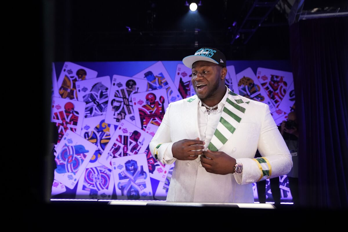 North Carolina State offensive tackle Ikem Ekwonu puts on a hat after being picked by the Carolina Panthers with the sixth pick of the NFL football draft Thursday, April 28, 2022, in Las Vegas. (AP Photo/John Locher)