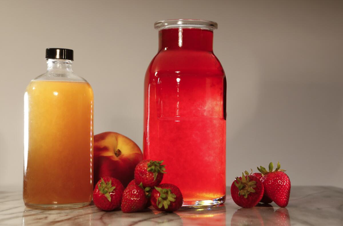 In Praise of Fraise (strawberry vodka), right, and Peach Bourbon, left, made in the Los Angeles Times studio on Aug. 6, 2015.