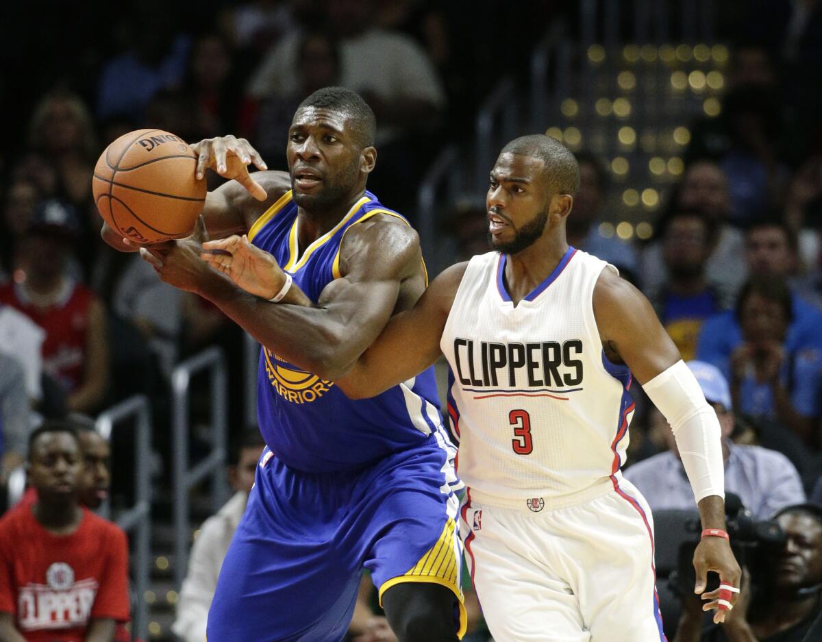 Golden State Warriors' Festus Ezeli, left, is defended by Los Angeles Clippers' Chris Paul during the first half of an NBA preseason basketball game Tuesday, Oct. 20, 2015, in Los Angeles.