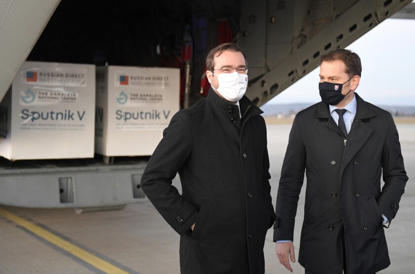 FILE - In this Monday March 1, 2021 file photo, Slovak Prime Minister Igor Matovic, right, and Health Minister Marek Krajci at Kosice Airport, Slovakia, as Russia's Sputnik V coronavirus vaccine arrives. Two parties in Slovakia’s ruling coalition called on the conservative prime minister to resign to open the way for a reconstruction of the government amid a political crisis triggered by a secret deal to buy Russia's coronavirus vaccine. (Frantisek Ivan/TASR via AP, File)