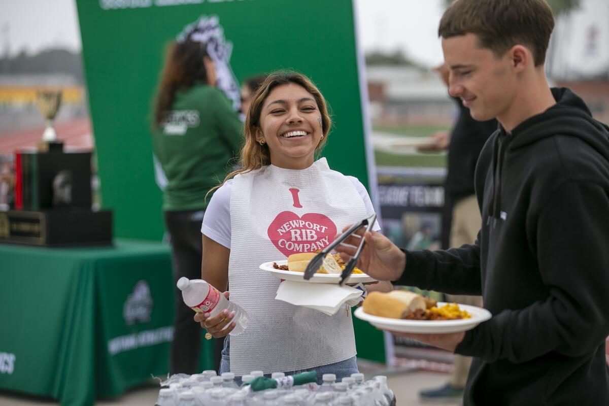 Itzel Ramirez, left, a girls' soccer player, and Ethan Smithlin, a boys' soccer and football player, prepare to eat lunch.