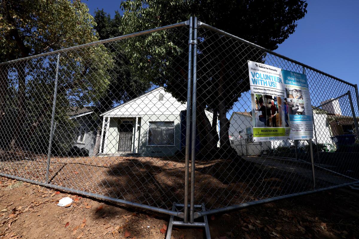 A house behind a chain-link fence.