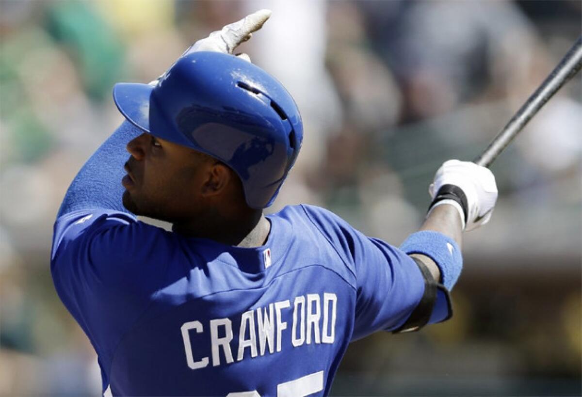 Dodgers outfielder Carl Crawford hits a solo home run against the Oakland Athletics during a spring training game.