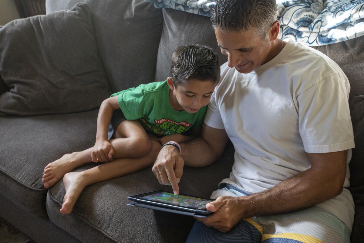 Jon Hatami plays a game with Jon Jr., 7, at home in Santa Clarita Valley.