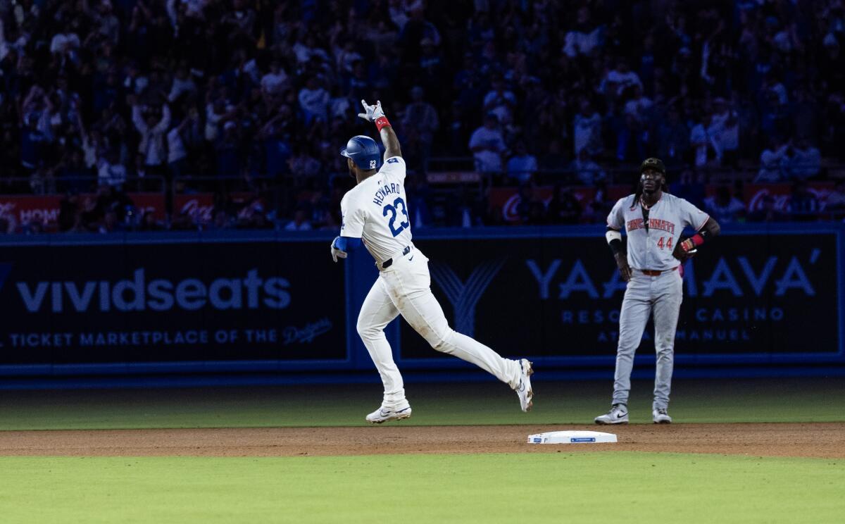 The Dodgers' Jason Heyward runs the bases in front of the Reds' Elly De La Cruz after hitting a two-run homer 