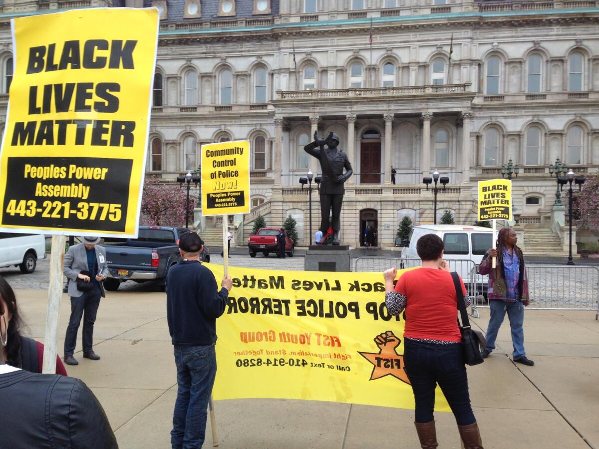 Demonstrators protest the death of Freddie Gray outside Baltimore City Hall on Monday.