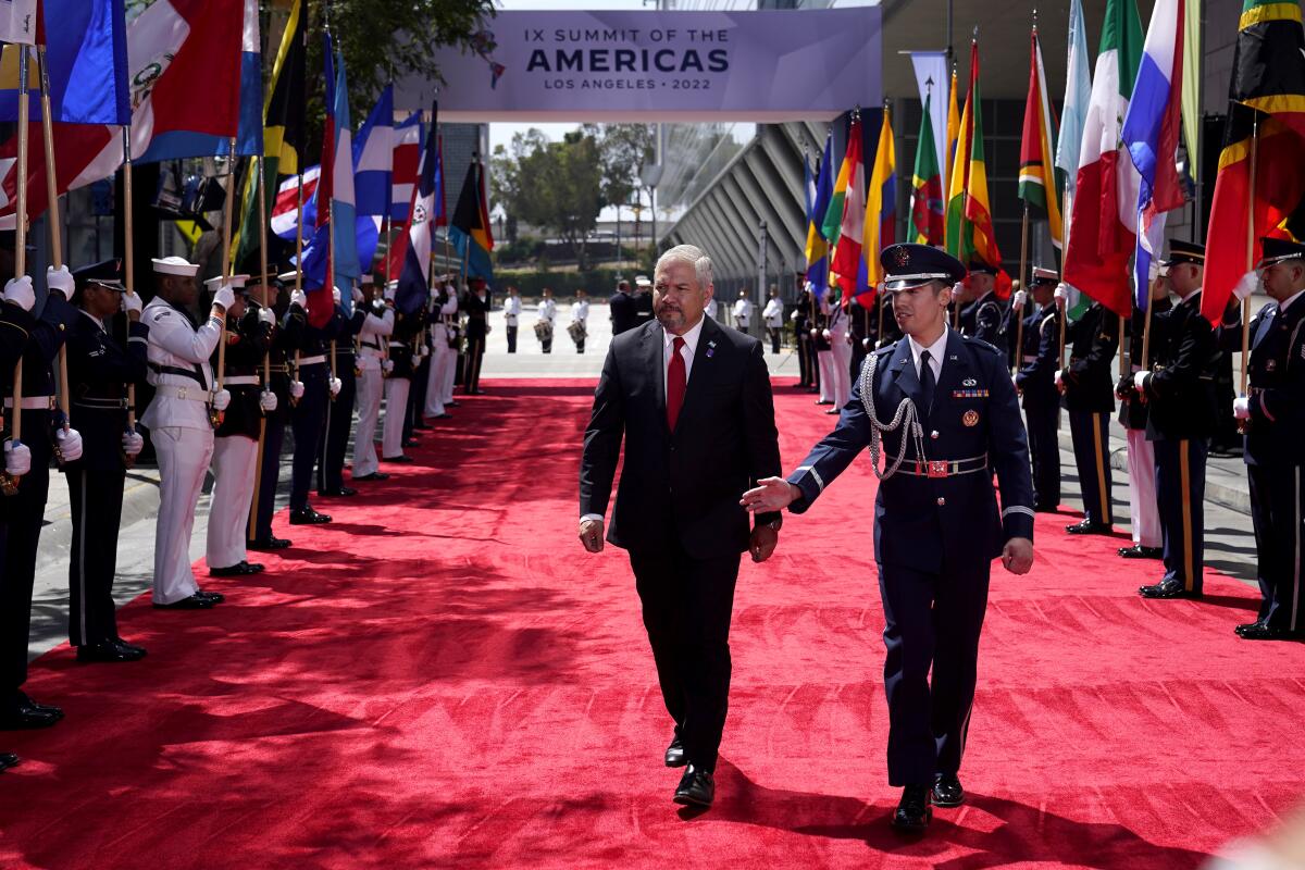 His Excellency Enrique Reina, Minister of Foreign Affairs and International Cooperation of the Republic of Honduras, left, walks on on the red carpet prior to the opening ceremony of the Summit of the Americas, Wednesday, June 8, 2022, in Los Angeles. (AP Photo/Marcio Jose Sanchez)