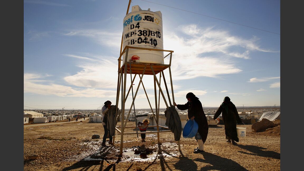 With no running water, residents collect water for cooking, cleaning and washing from water tanks around the camp.