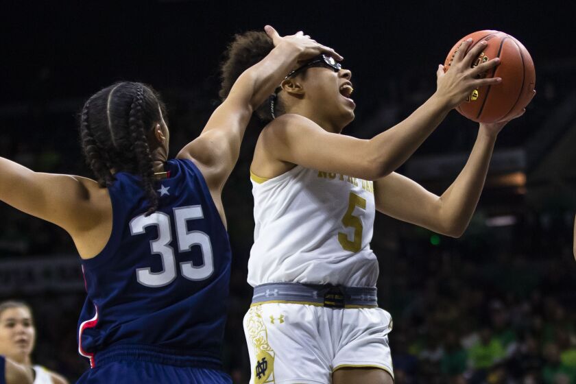 Notre Dame's Olivia Miles (5) tries to drive past Connecticut's Azzi Fudd (35) during the first half of an NCAA college basketball game on Sunday, Dec. 4, 2022, in South Bend, Ind. (AP Photo/Michael Caterina)