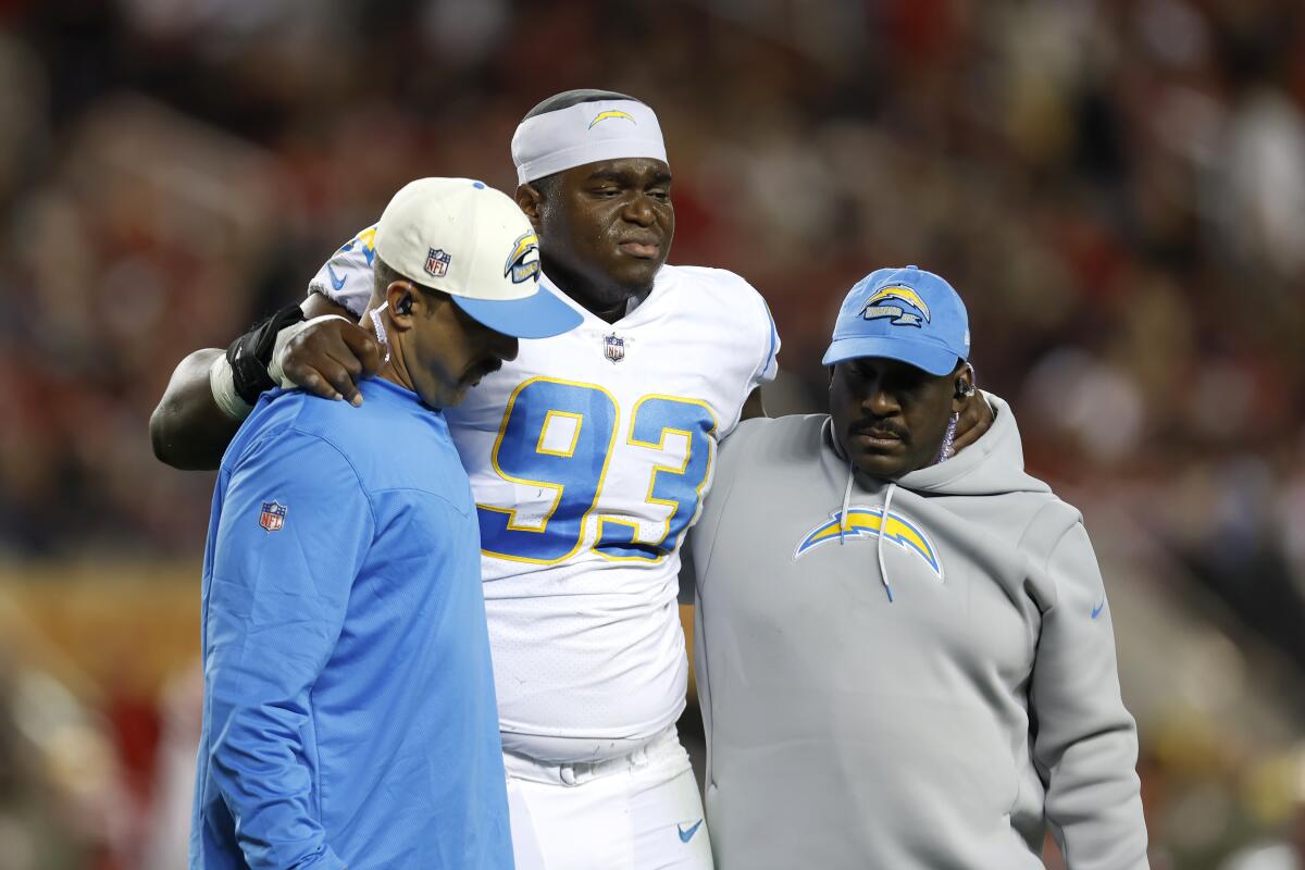 Chargers defensive tackle Otito Ogbonnia (93) is helped off the field after suffering a ruptured patellar tendon.